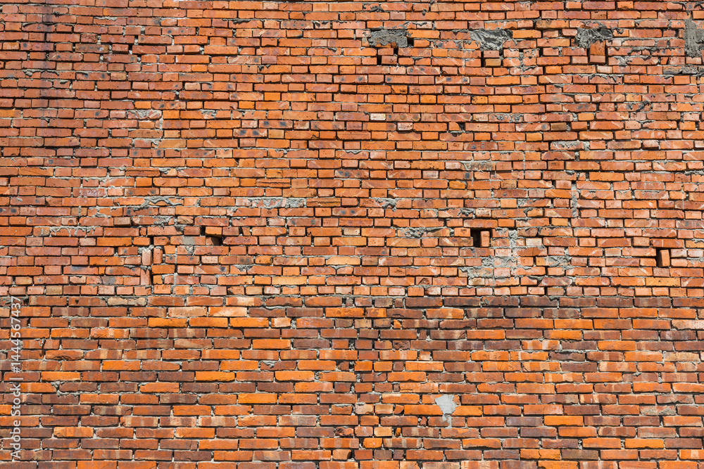 Naklejka premium Red brick wall with rough aged surface details