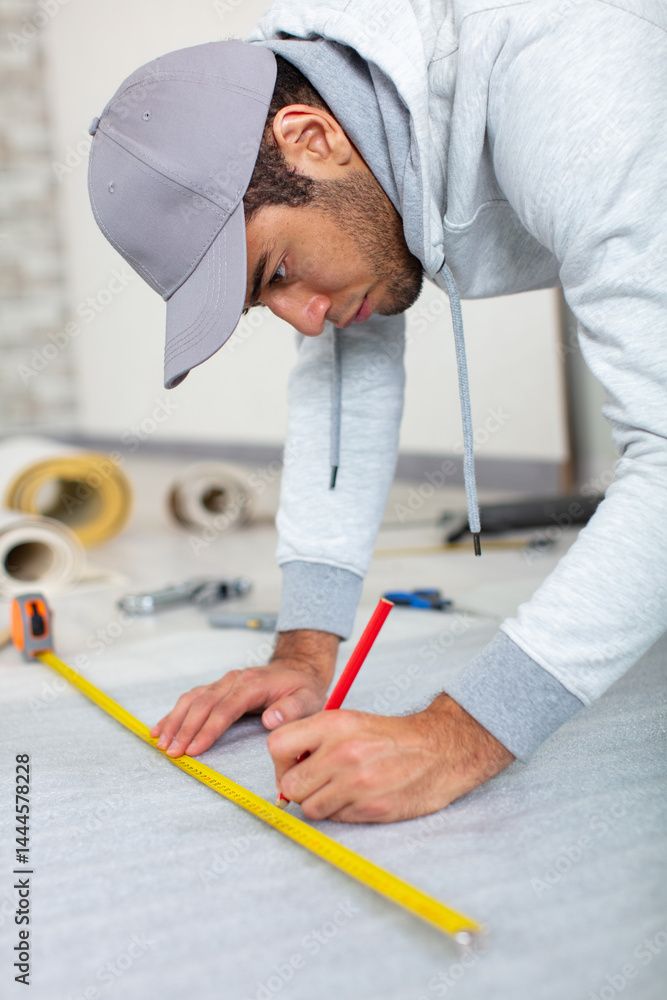 a young man holds a level for measuring floor