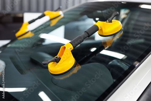 Suction pads for car windshield installing in workshop.