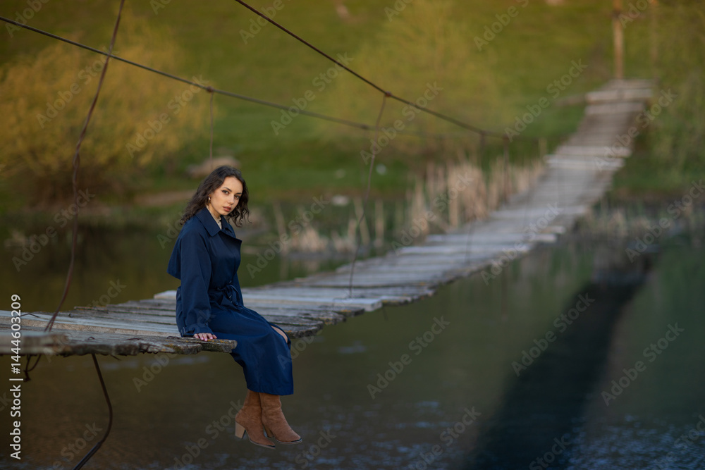 beautiful brunette european girl in blue trench coat at nature. Young lady with beautiful face.