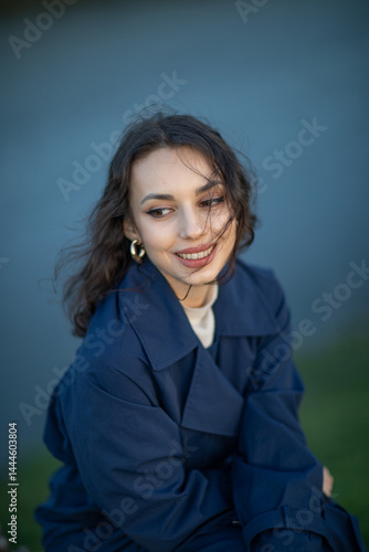 Obraz na płótnie beautiful brunette european girl in blue trench coat at nature. Young lady with beautiful face. w salonie