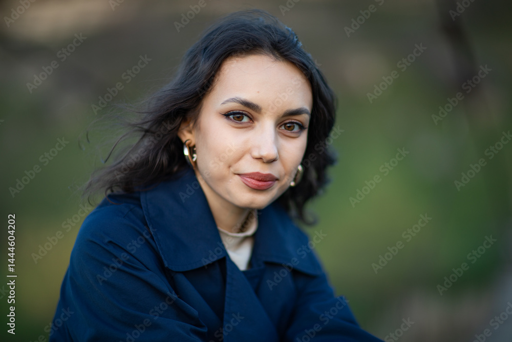 beautiful brunette european girl in blue trench coat at nature. Young lady with beautiful face.