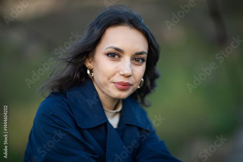 Obraz na płótnie beautiful brunette european girl in blue trench coat at nature. Young lady with beautiful face. w salonie