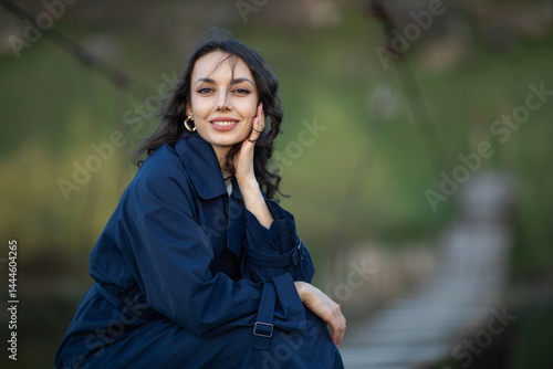 Obraz na płótnie beautiful brunette european girl in blue trench coat at nature. Young lady with beautiful face. w salonie