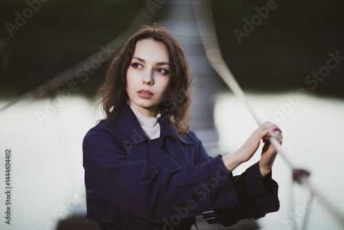 Obraz na płótnie beautiful brunette european girl in blue trench coat at nature. Young lady with beautiful face. w salonie