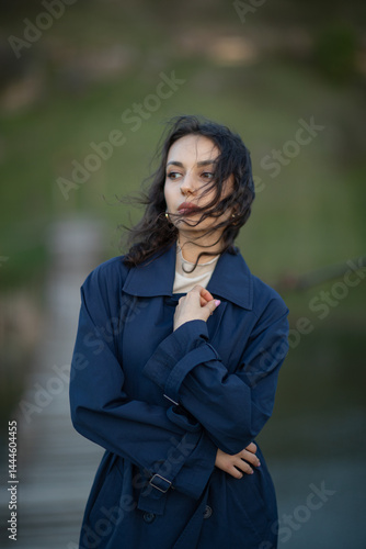 Obraz na płótnie beautiful brunette european girl in blue trench coat at nature. Young lady with beautiful face. w salonie