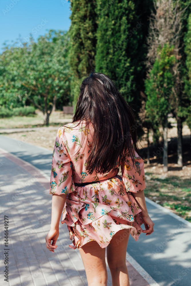 Naklejka premium women in a summer dress with flowers walking in a spring park