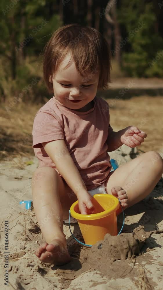 Vertical video. A toddler joyfully playing with sand outdoors, embracing childhood freedom and creativity Vertical video. A toddler joyfully playing with sand outdoors, embracing childhood freedom and creativity