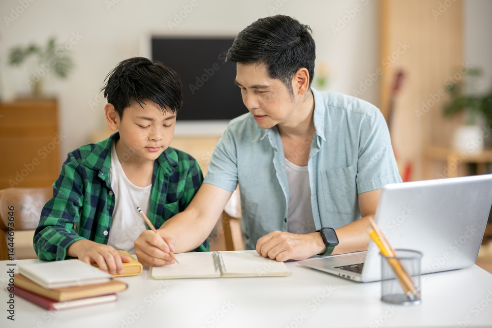 The father is teaching his son his homework with care at his home. The father is teaching his son his homework with care at his home.