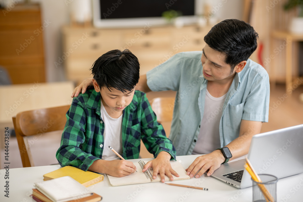 The father is teaching his son his homework with care at his home. The father is teaching his son his homework with care at his home.