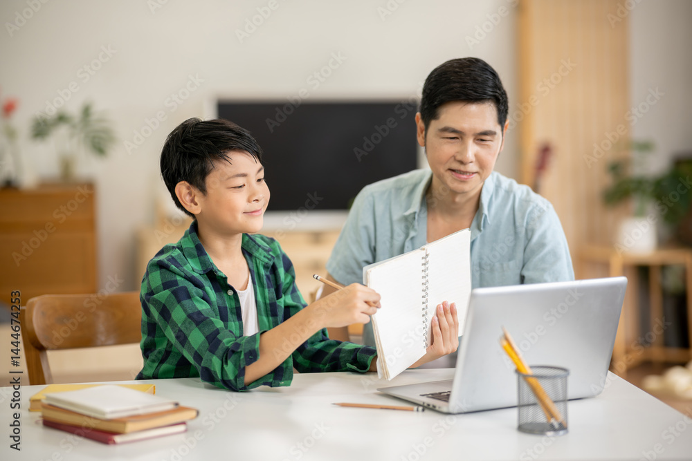 The father is teaching his son his homework with care at his home. The father is teaching his son his homework with care at his home.