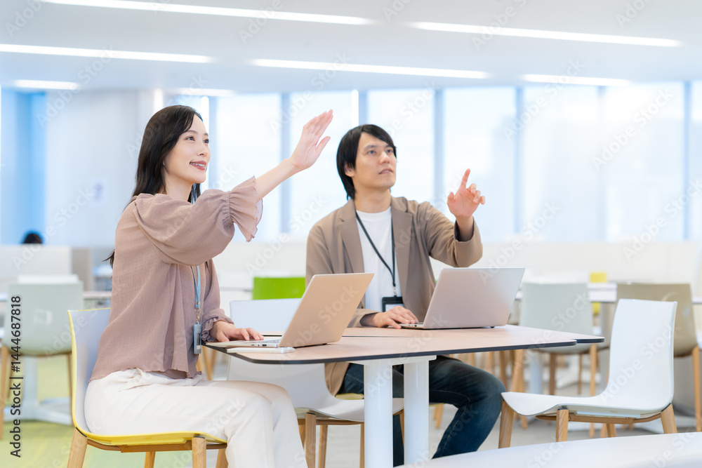 Fototapeta premium オフィスで打ち合わせをする若い男女のエンジニア 撮影協力：学校法人電波学園 東京電子専門学校