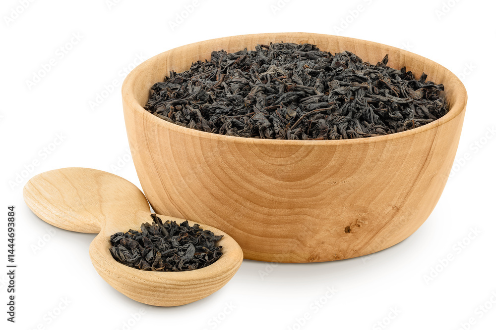 Dry black tea leaves in wooden bowl and spoon isolated on white background Dry black tea leaves in wooden bowl and spoon isolated on white background
