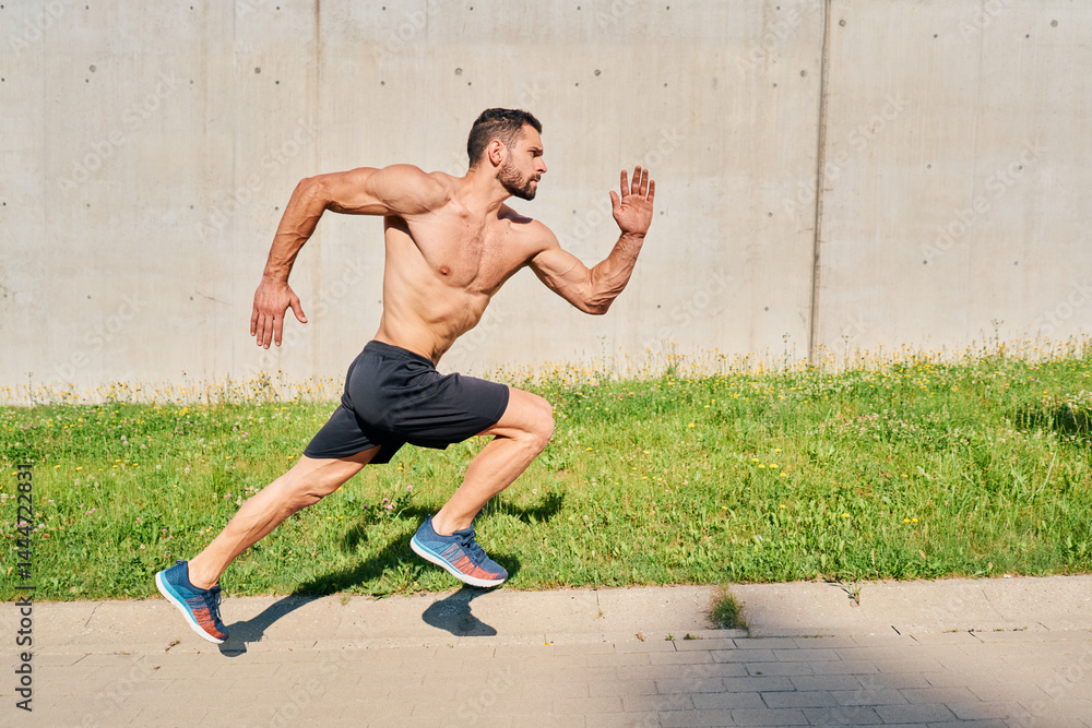 Fototapeta premium Athlete sprinting during running drills in a city