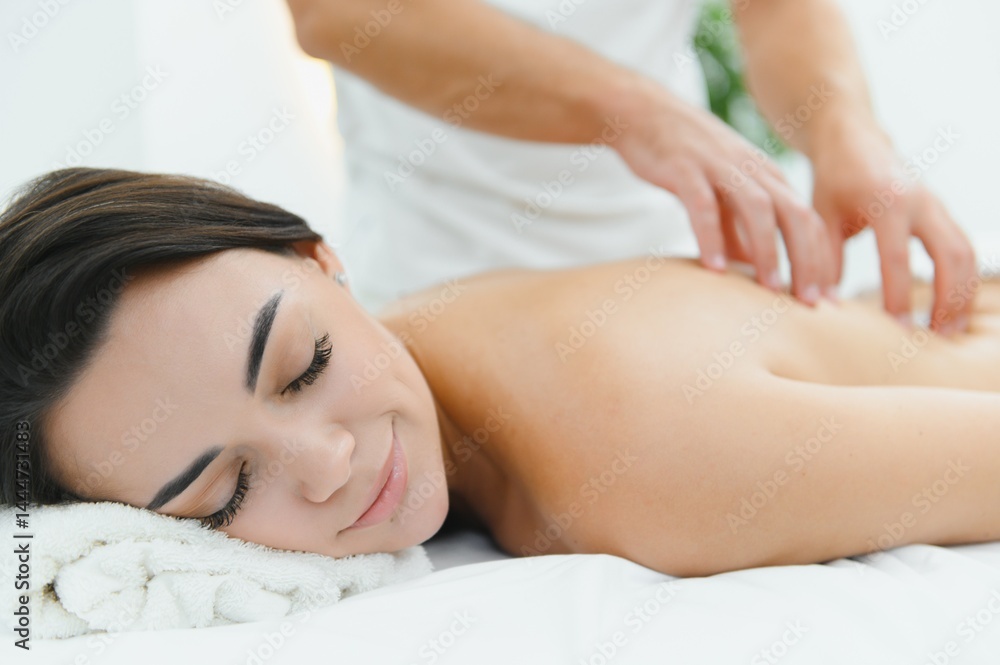 Young woman getting back massage in spa salon Young woman getting back massage in spa salon
