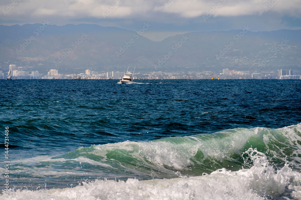 Wave forms giving a dramatic luster to the water with a boat in the background sitting on the horizon