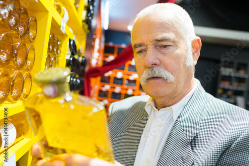customer holding a bottle of yellow liquor