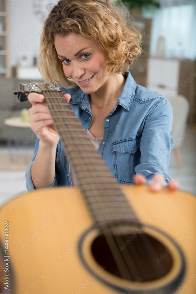 woman checking the strings on her guitar
