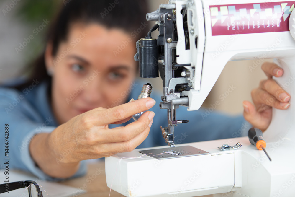 woman changing the bulb in a sewing machine