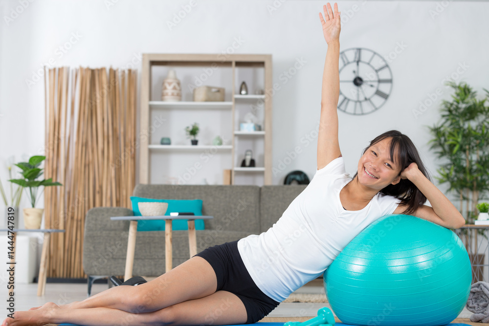 attractive asian lady exercising on an aerobic ball