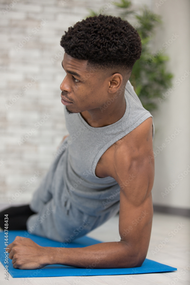 man at the gym doing stretching exercises on the floor