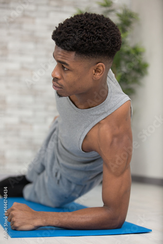 Obraz na płótnie man at the gym doing stretching exercises on the floor w salonie