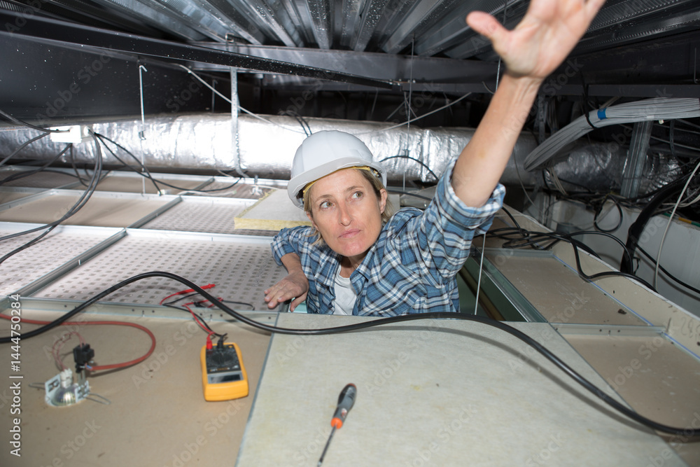 female electrician wiring a large room