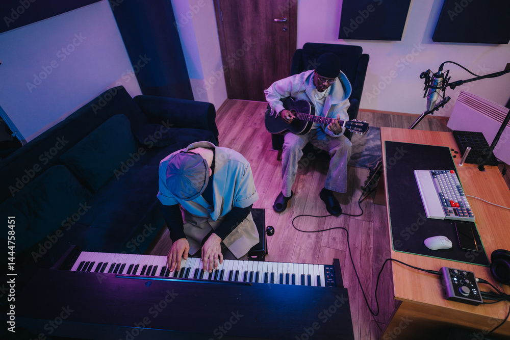 Two musicians, one playing a keyboard and the other a guitar, work together in a contemporary recording studio. The inviting space is filled with musical instruments and professional equipment.