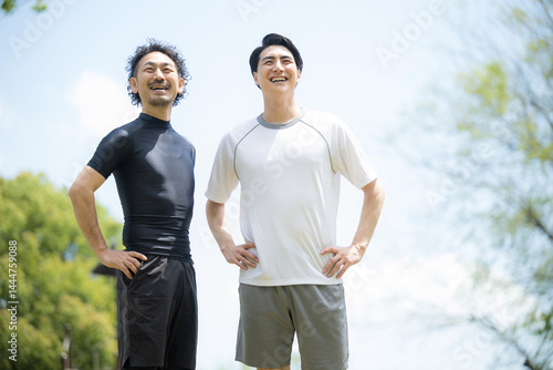 Two fresh men sporting two in a blue sky, looking up at the sky.