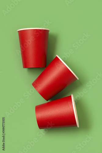 Obraz na płótnie Disposable red paper cups on a green top view, mockup. No plastic and sustainable Christmas w salonie