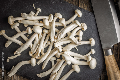 Obraz na płótnie Raw white shimeji mushrooms on cutting board. Top view. w salonie