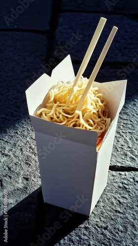 Delicious noodles served in a takeout box against a textured stone surface in bright sunlight Generative AI
