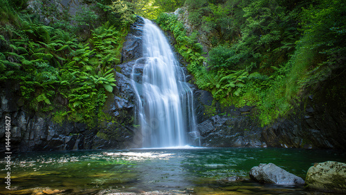 A majestic mountain waterfall cascading down rocky cliffs into a crystal-clear pool below, surrounded by lush greenery and mist rising from the water.