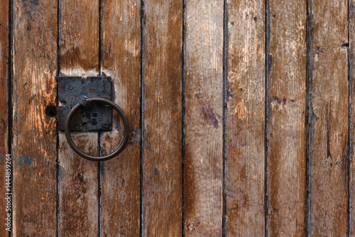 Obraz na płótnie Close-up of an aged wooden door featuring a metal ring handle w salonie