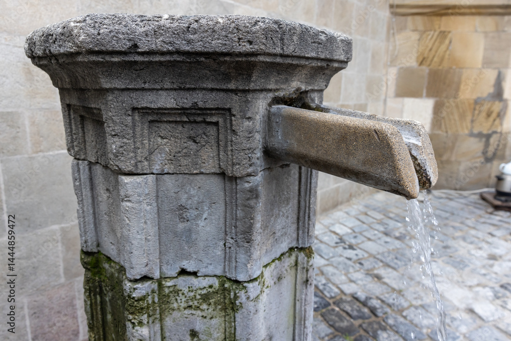 Rustic scene of an old stone fountain flowing with water, Baku