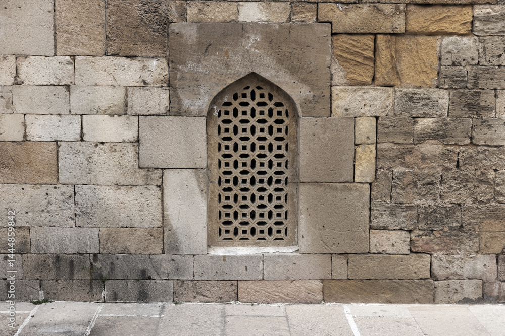 Historic stone wall featuring a beautifully crafted decorative window