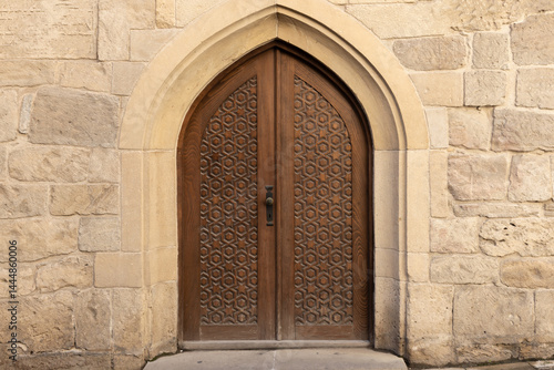 Beautiful handcrafted wooden door set within a detailed stone archway