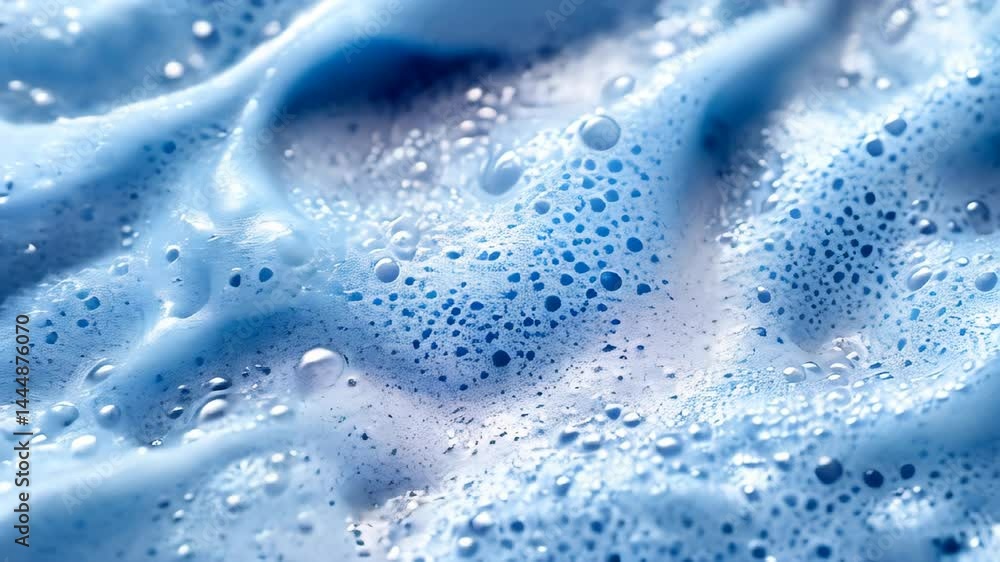 Close-up view showcases vibrant blue foam with intricate bubbles formed in water play. The mesmerizing textures shift and swirl as light filters through, creating a captivating visual. Close-up view showcases vibrant blue foam with intricate bubbles formed in water play. The mesmerizing textures shift and swirl as light filters through, creating a captivating visual.