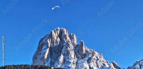 Panorama of a parachutist flying over a mountain.