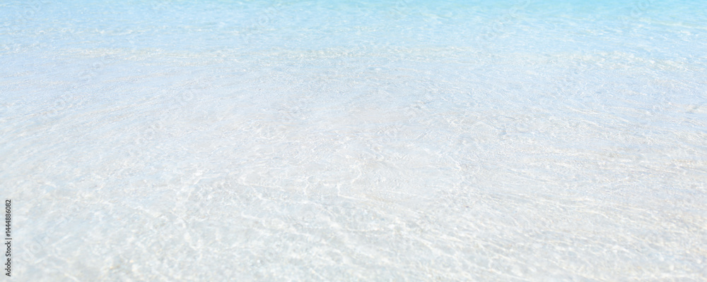 Obraz premium Close-up view of calm clear water over white sand at a tropical beach, perfect for wellness, travel, relaxation, spa, copy space backgrounds and peaceful minimalist summer visuals.