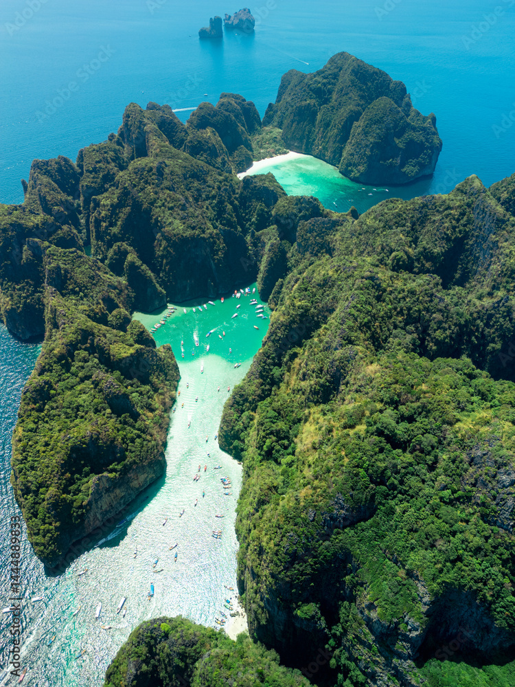 High-angle aerial photo of Maya Bay with green cliffs and vivid sea in Thailand, perfect for exotic beach travel, eco-tourism ads, summer getaways, nature backgrounds and adventure promotions.