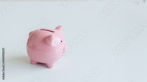 Obraz na płótnie Cute pink piggy bank sitting on a white surface, symbolizing saving money and financial planning for individuals and families w salonie