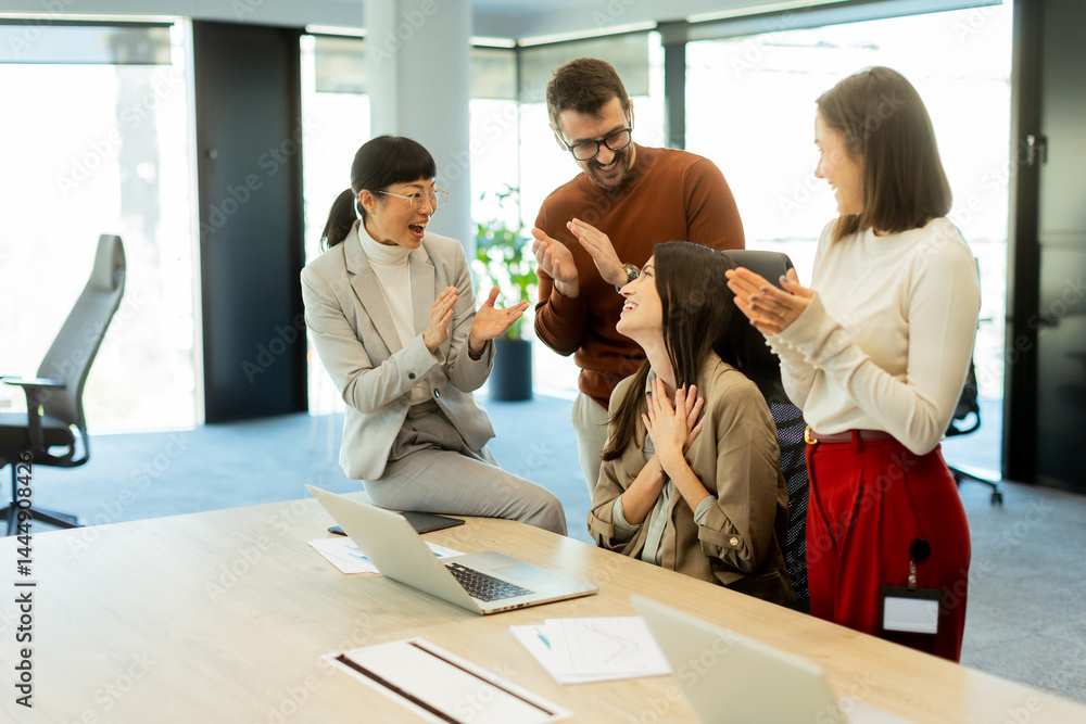 Team celebrates success together in a bright modern office environment