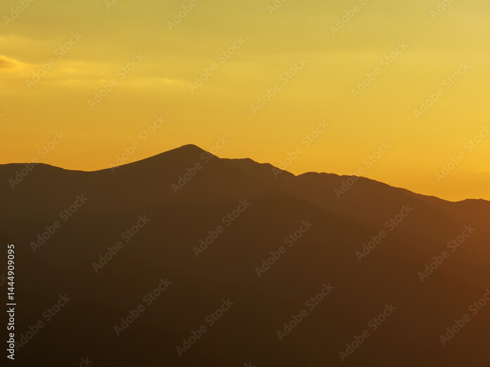 Drone shot over Pirin mountain range, Bulgaria, golden sunset lighting summer ridges, creating sense of depth and tranquility, ideal silhouette for nature and travel themes. Travel tourism concept Drone shot over Pirin mountain range, Bulgaria, golden sunset lighting summer ridges, creating sense of depth and tranquility, ideal silhouette for nature and travel themes. Travel tourism concept