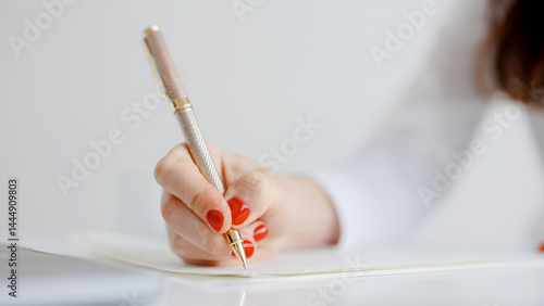 Obraz na płótnie Writing with a sleek pen on clean paper in a bright workspace during the daytime w salonie