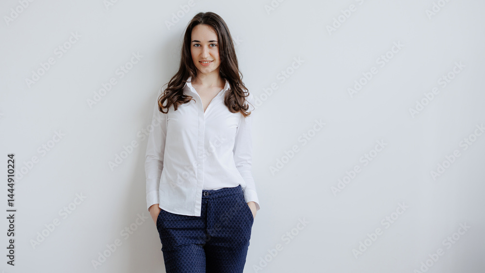 Woman posing confidently in a stylish outfit against a neutral backdrop in a well-lit environment