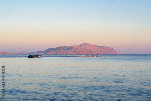 Obraz na płótnie Sunrise casts soft hues over tranquil waters near desert island in early morning w salonie