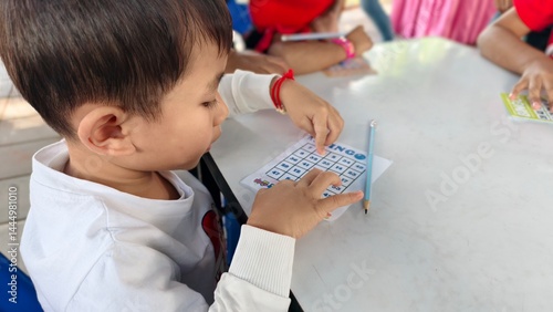Child Playing Bingo Game with Focused Expression