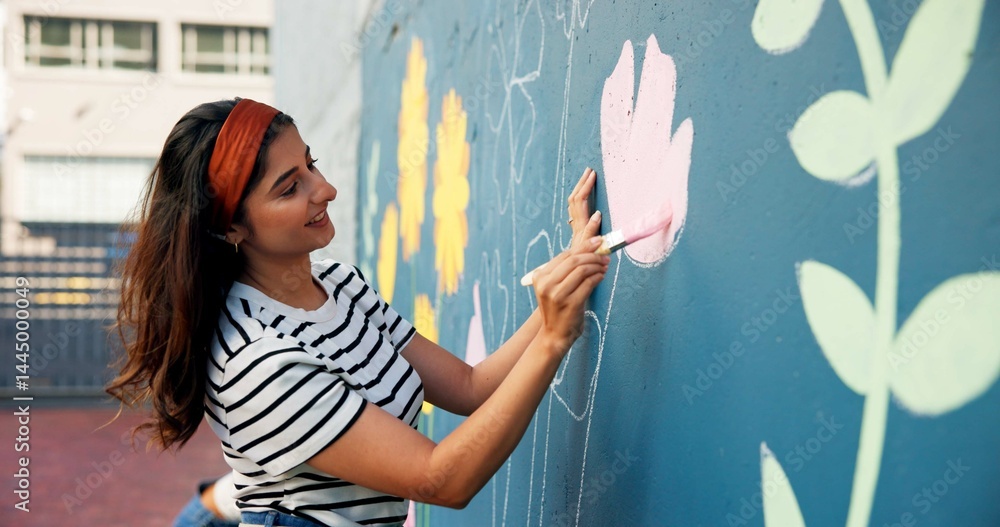 Obraz premium Painting, happy and woman with wall for mural art design, creative project and community service. Artist, volunteer and person with paintbrush for flower decor, inspiration and DIY hobby in city