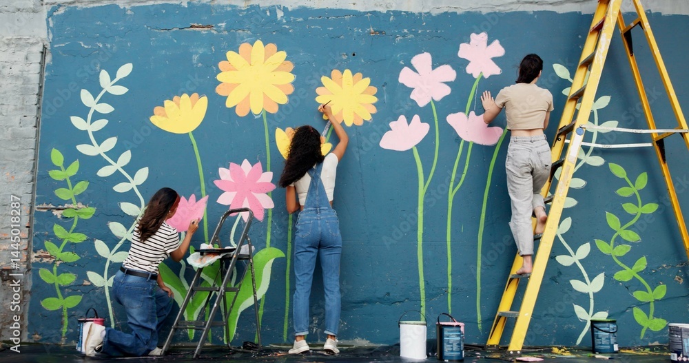 Fototapeta premium Wall art, women and painting mural outdoor for sustainable awareness, community project or creative teamwork. Flower decoration, people and floral inspiration for DIY public design, earth day or back